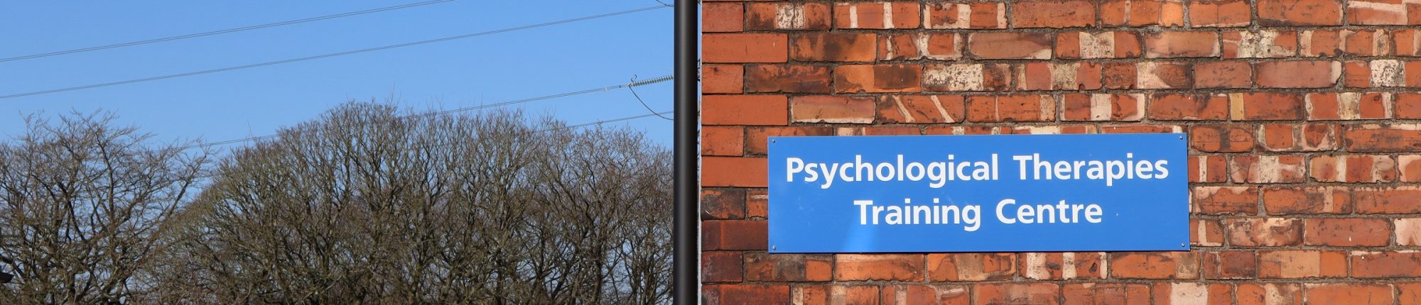 PTTC sign on a brick wall on a sunny day